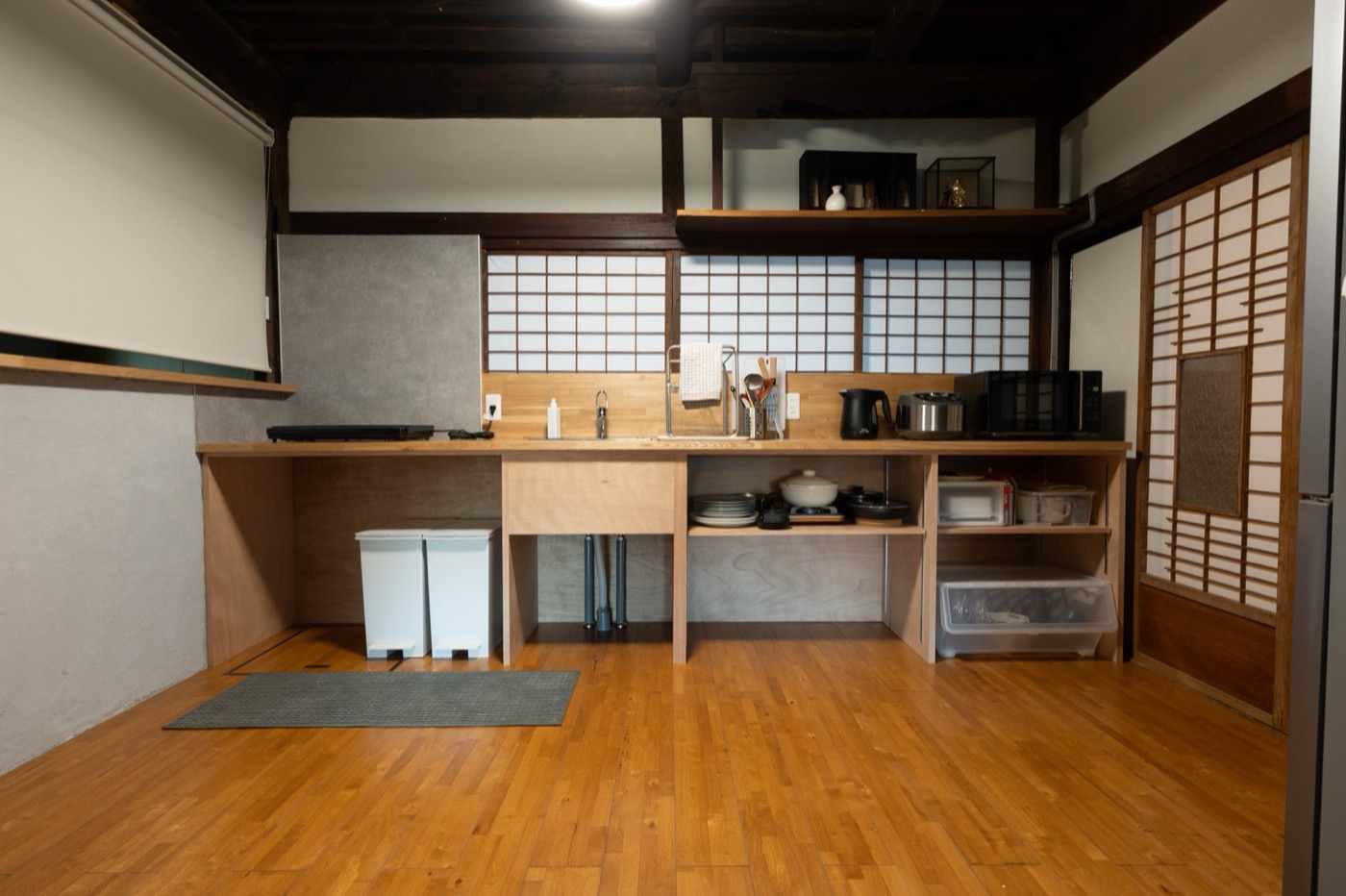 川口建築が造作した共用の台所。障子を背にしたカウンターと、使いやすく整えた水回り