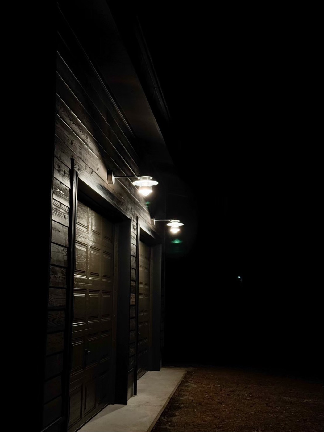 ガレージ外壁夜景。外灯2灯に照らされるブラックウォール